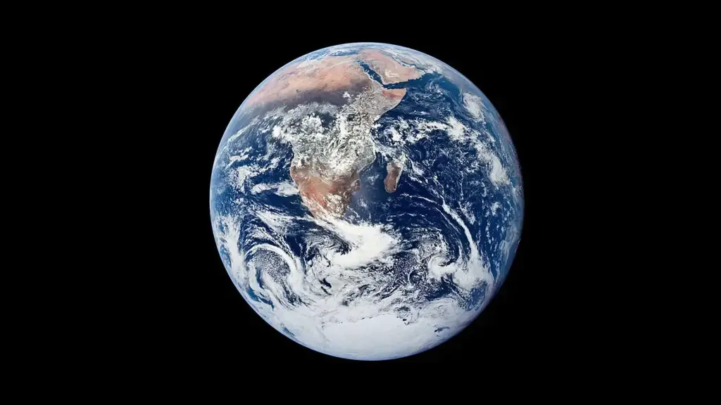 Earth shines brightly in shades of blue and green, with swirling white clouds blanketing parts of the oceans and landmasses. The polar caps glisten with icy brilliance.
